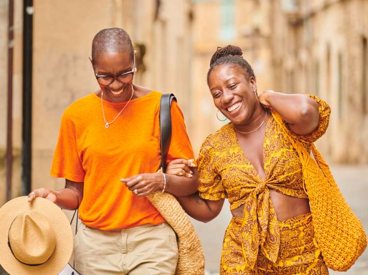 Mature mother and adult daughter strolling around a traditional old town in Majorca Spain.