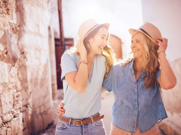 Grandmother and adult granddaughter tourists on summer vacations walking together in an old town