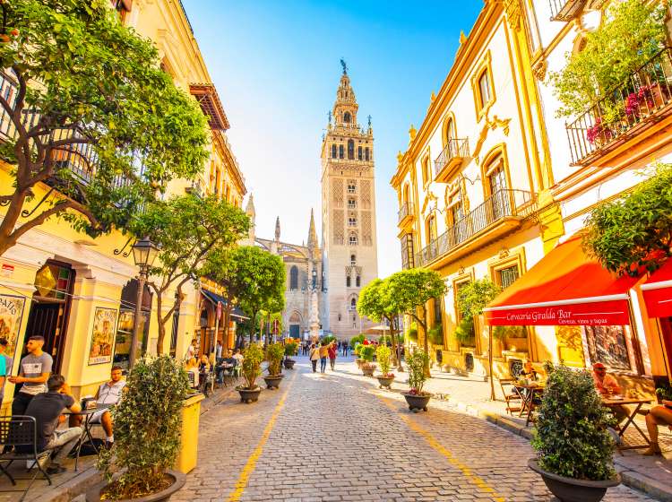 Seville, Spain - 6 March 2020: Sunny Seville street and scenic view of Giralda tower