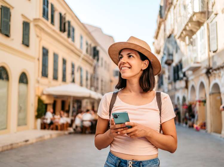 Beautiful young female tourist enjoying the architecture of Corfu Town, Greece.