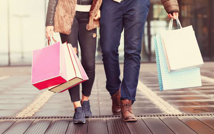 Couple holding hands, carrying shopping bags