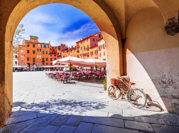 Lucca, Italy - View of Piazza dell'Anfiteatro square through the arch, ancient Roman Empire amphitheater, famous Tuscany.