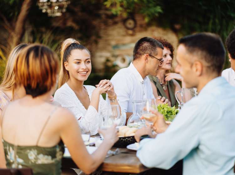 Group of diverse people enjoying summer afternoon and evening in garden party