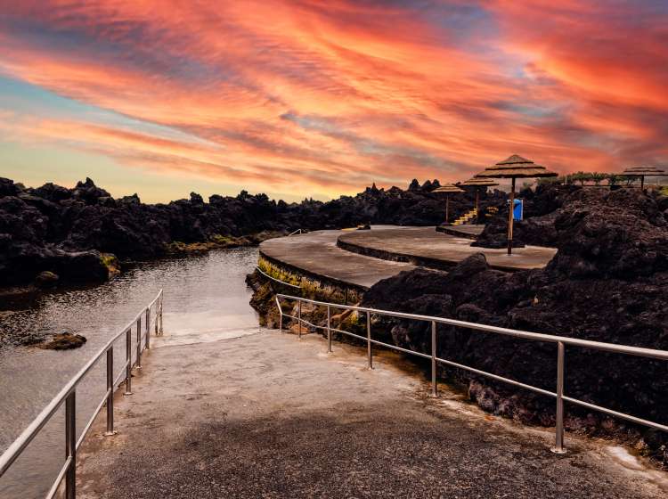 Natural pools at Biscoitos during a dramatic sunset in the coast of Terceira Island, Azores, Portugal