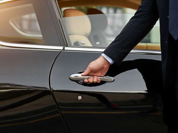 Cropped shot of an unrecognizable male chauffeur opening a car door