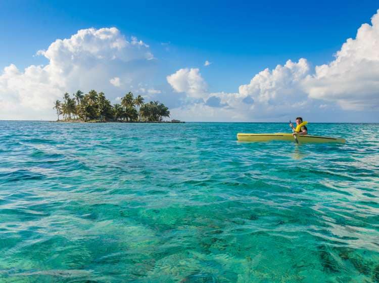 Kayaking in tropical paradise - Canoe floating on transparent turquoise water, caribbean sea, Belize, Cayes islands; Shutterstock ID 1046802043; Invoice Number: -