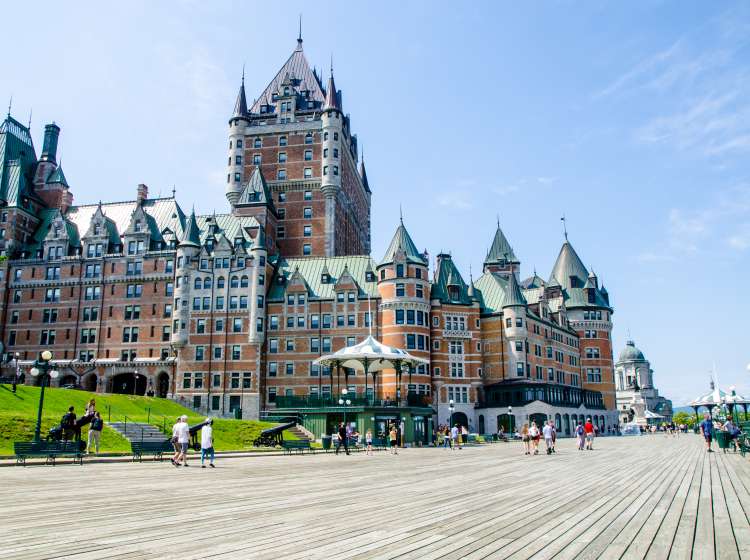 Dufferin boardwalk with people, cannon and ChÃ¢teau Frontenac during nice day of springtime in Old Quebec