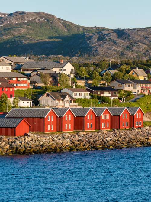 Houses near water infront of mountains