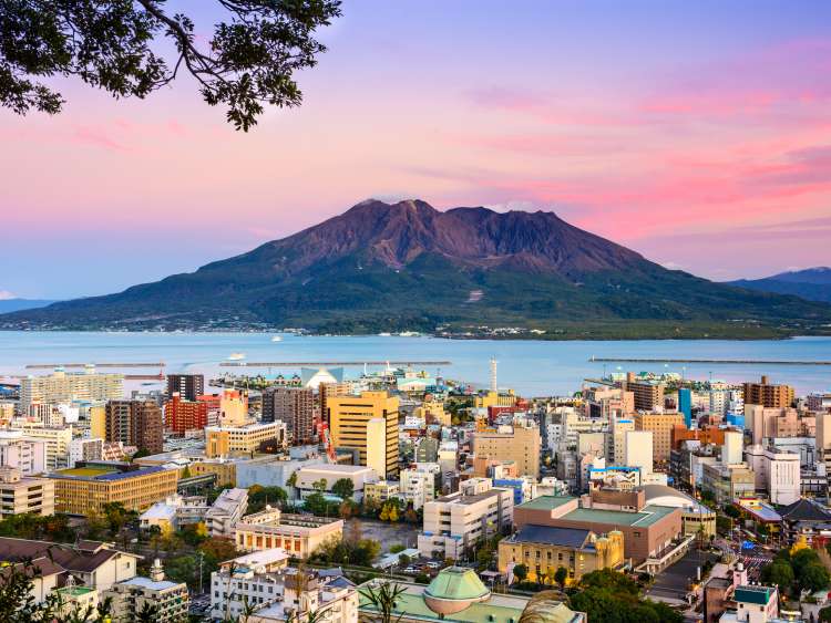 image of city in front of sea and huge mountain