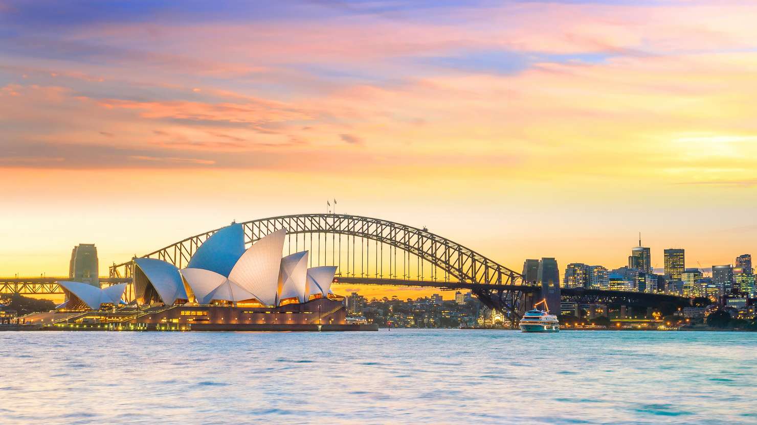 View of Sydney opera house and bridge behind it in sunset