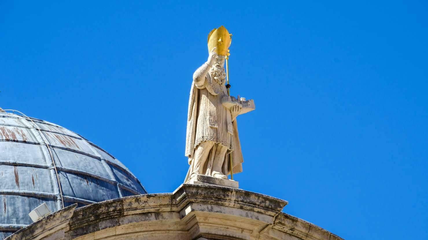 Statue of Saint Blaise on top of the facade of the baroque Church of St. Blaise in the old city of Dubrovnik. The saint shows in his left hand a scale model of the Romanesque church which was destroyed by the earthquake in 1667.