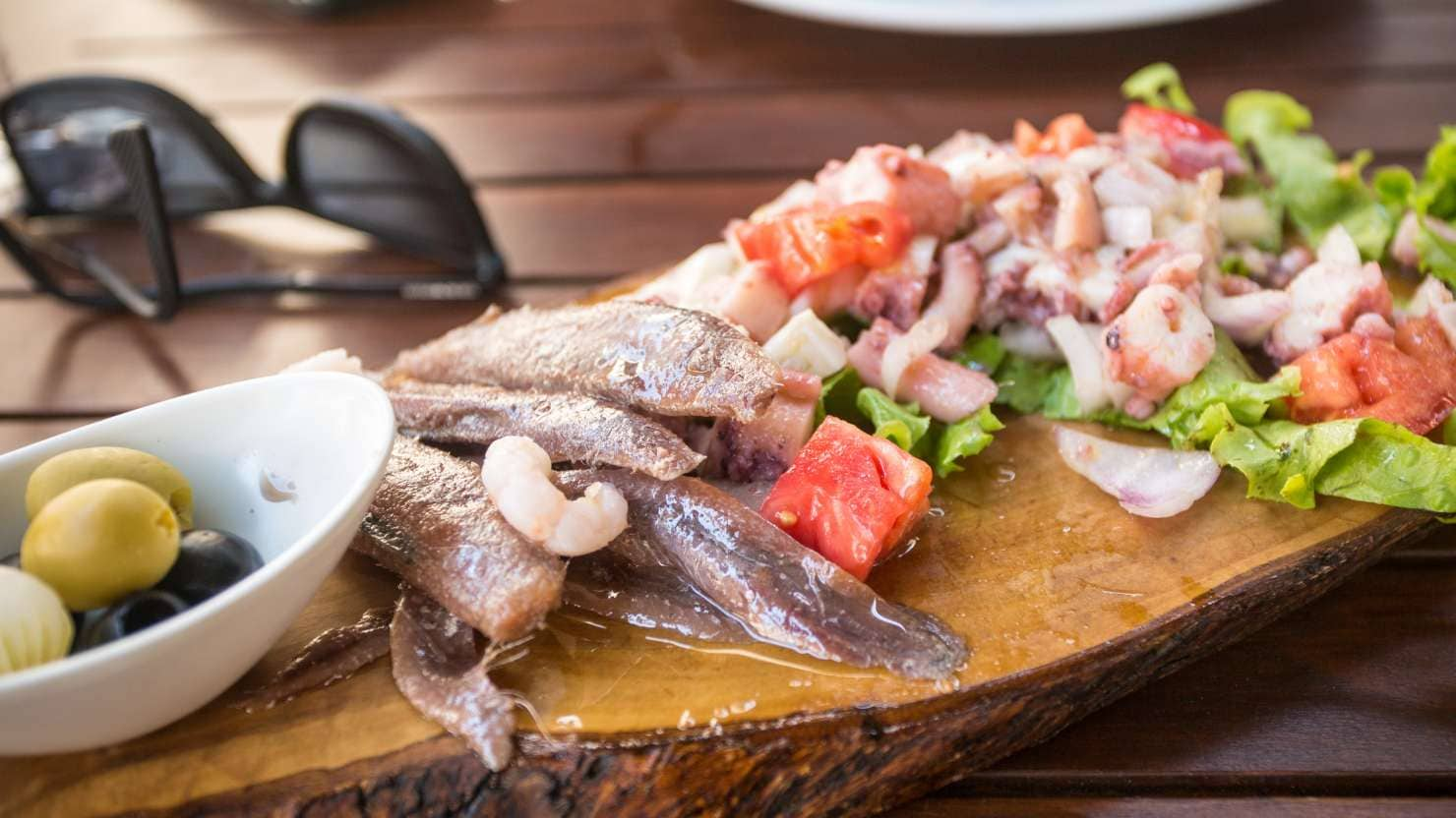 Fresh mix of seafood served on wooden platter