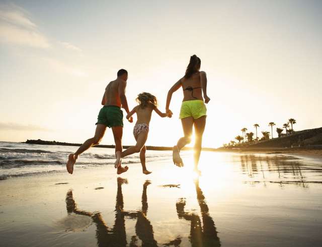 Family running together on beach