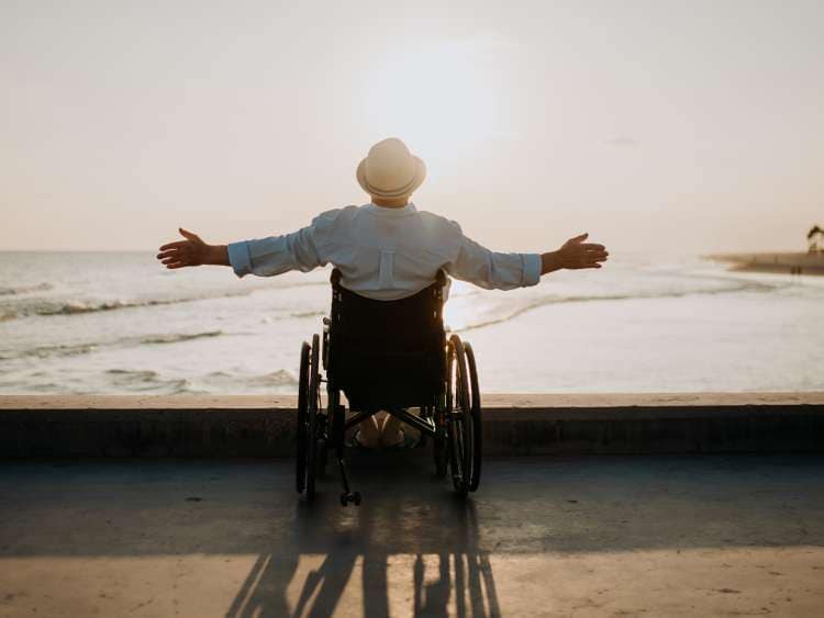 Rear view of man on wheelchair enjoying exotic holiday.