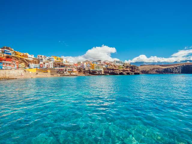 Cristall clear water and unspoiled canarian landscape at the beautiful fishing village of Sardina del Norte with its colorful houses. 