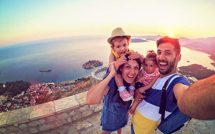 Family with two little daughters travel in nature, making selfie, smiling