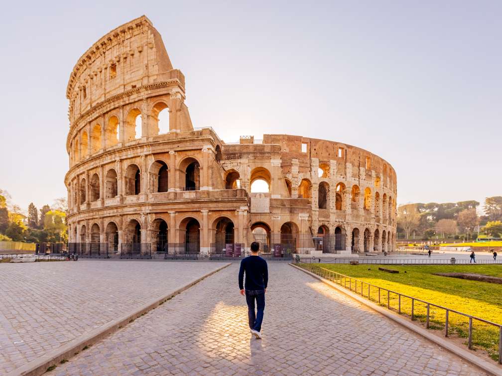 Rear view of a man walking towards Coliseum, Rome, Italy