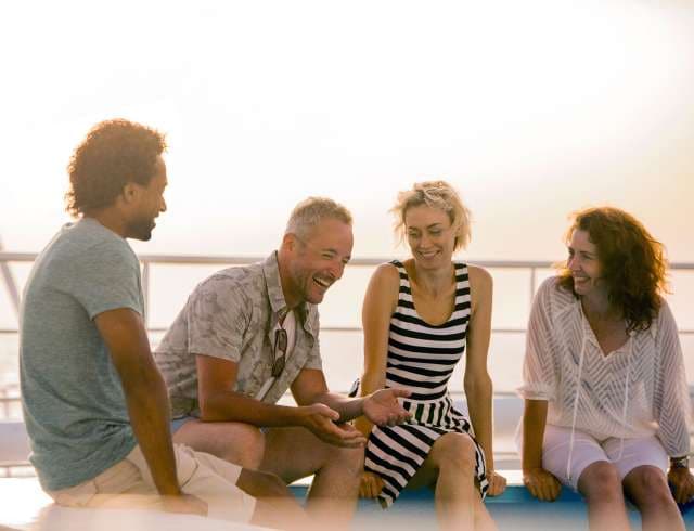 Friends laughing together on sunbed on deck of P&O Cruises ship