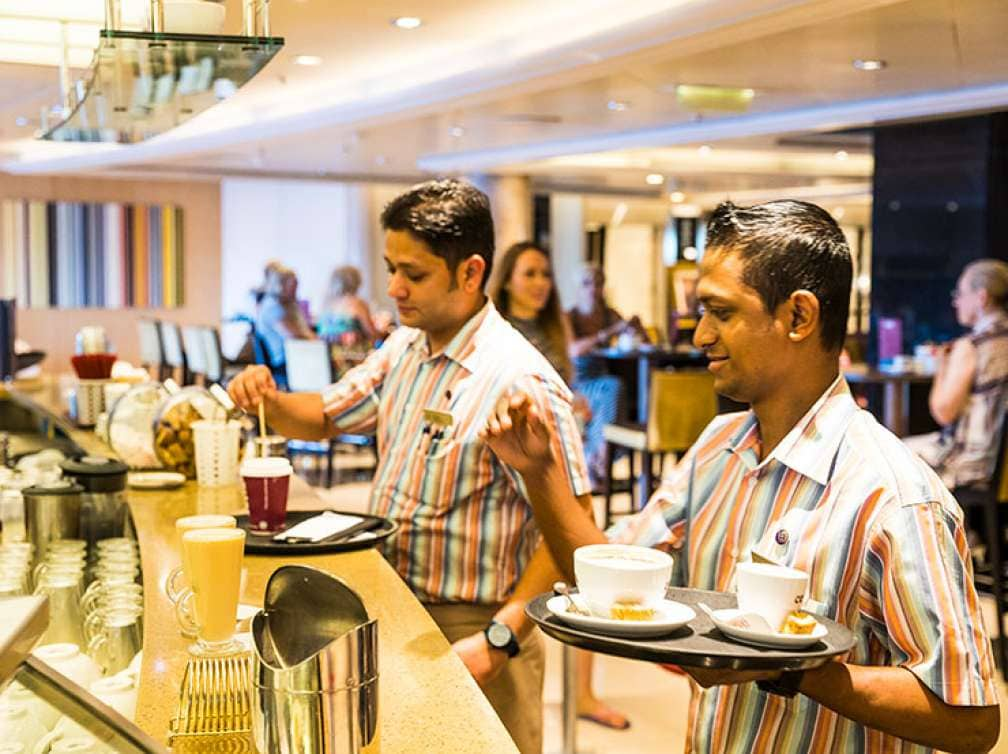 Waiters serving drinks in Java bar on P&O Cruises ship Azura