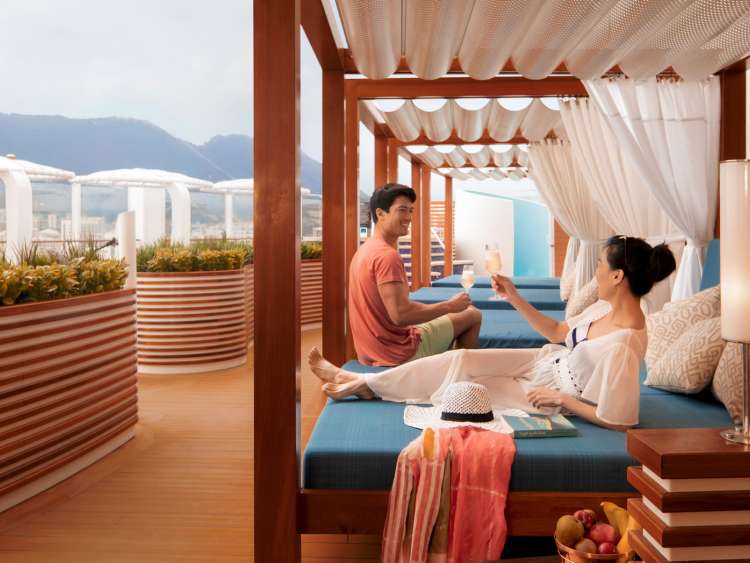 Couple enjoying a drink on a sunbed in The Retreat on P&O Cruises ship Iona