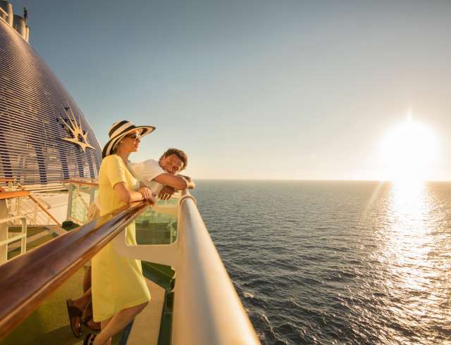 Man and women looking at sunset on deck