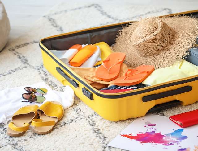 Open packed suitcase on floor in room. Travel concept; Shutterstock ID 1984123145; project: po; job: po; client: po; other: 