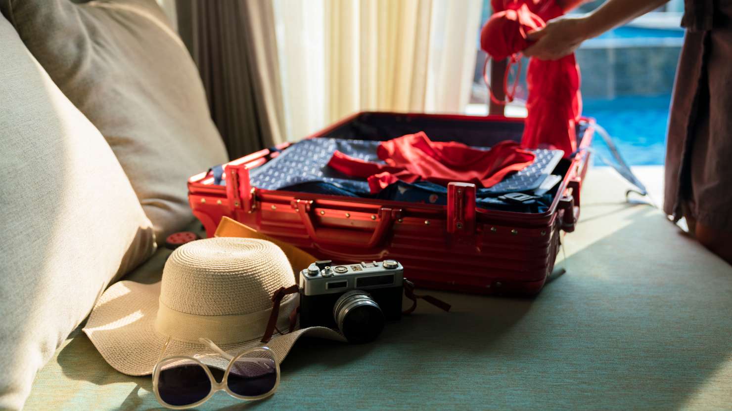 woman packing suitcase for summer trip.